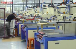 越南一處工廠生產線上，作業員在自動化設備旁進行加工與品管作業。越南媒體指出，在內外部不確定性升高之際，企業正加速強化營運「內功」，以提升抗風險能力。（圖片翻攝自 VnBusiness）