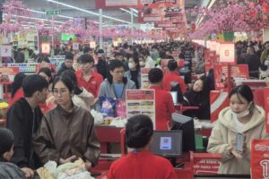 越南超市於2026年農曆新年前夕湧現採購人潮，顧客在收銀台前等待結帳。零售商表示春節期間客流量與銷售額較促銷初期成長兩至三成。圖片來源：越南勞動報（Lao Động）